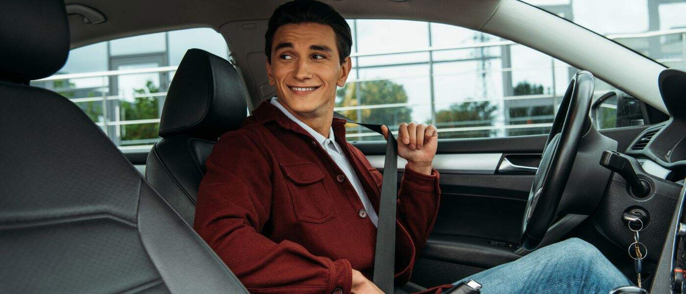 A man putting on his seatbelt in Denver, CO